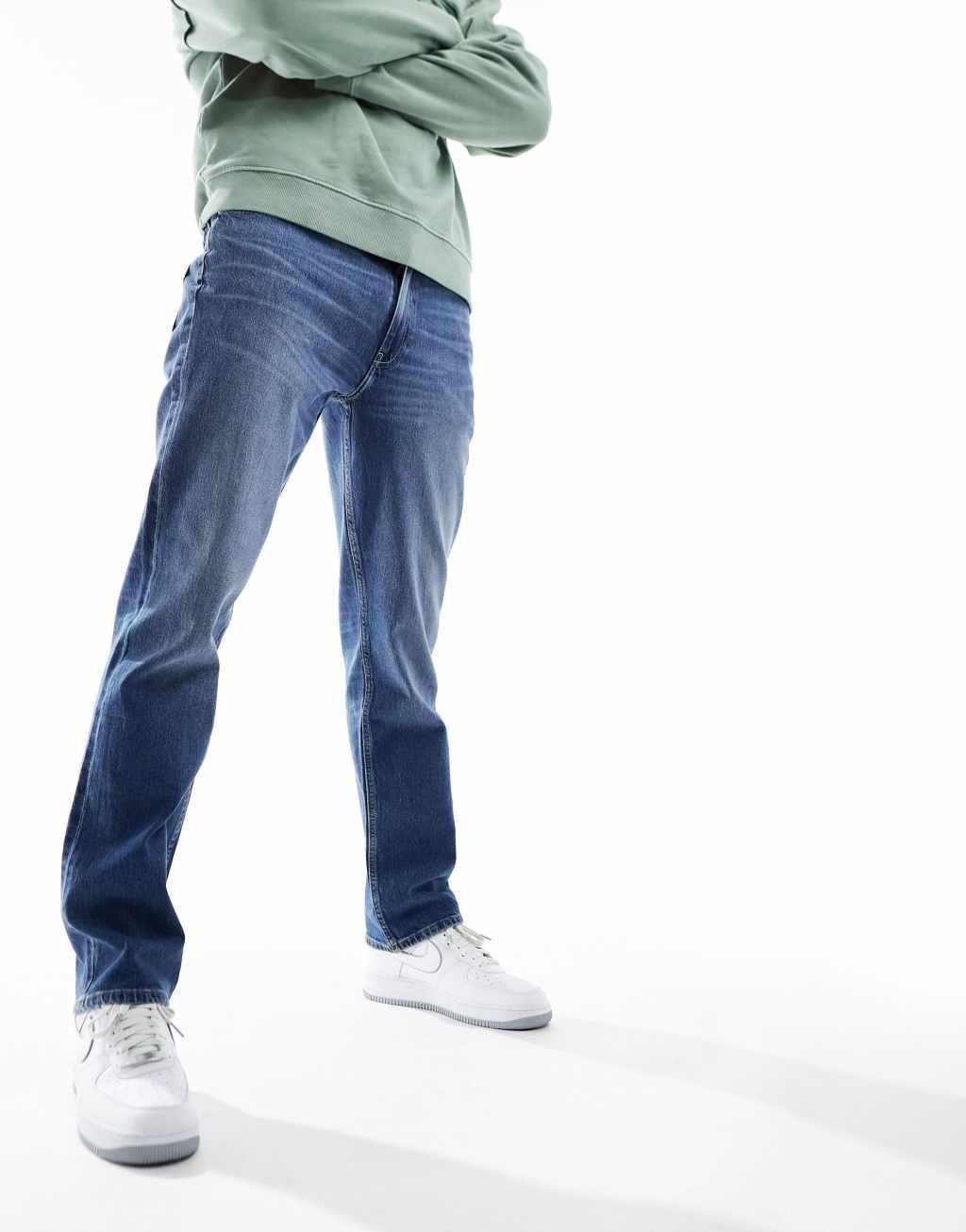 ASOS DESIGN straight leg jeans with stretch in mid wash blue Product Image