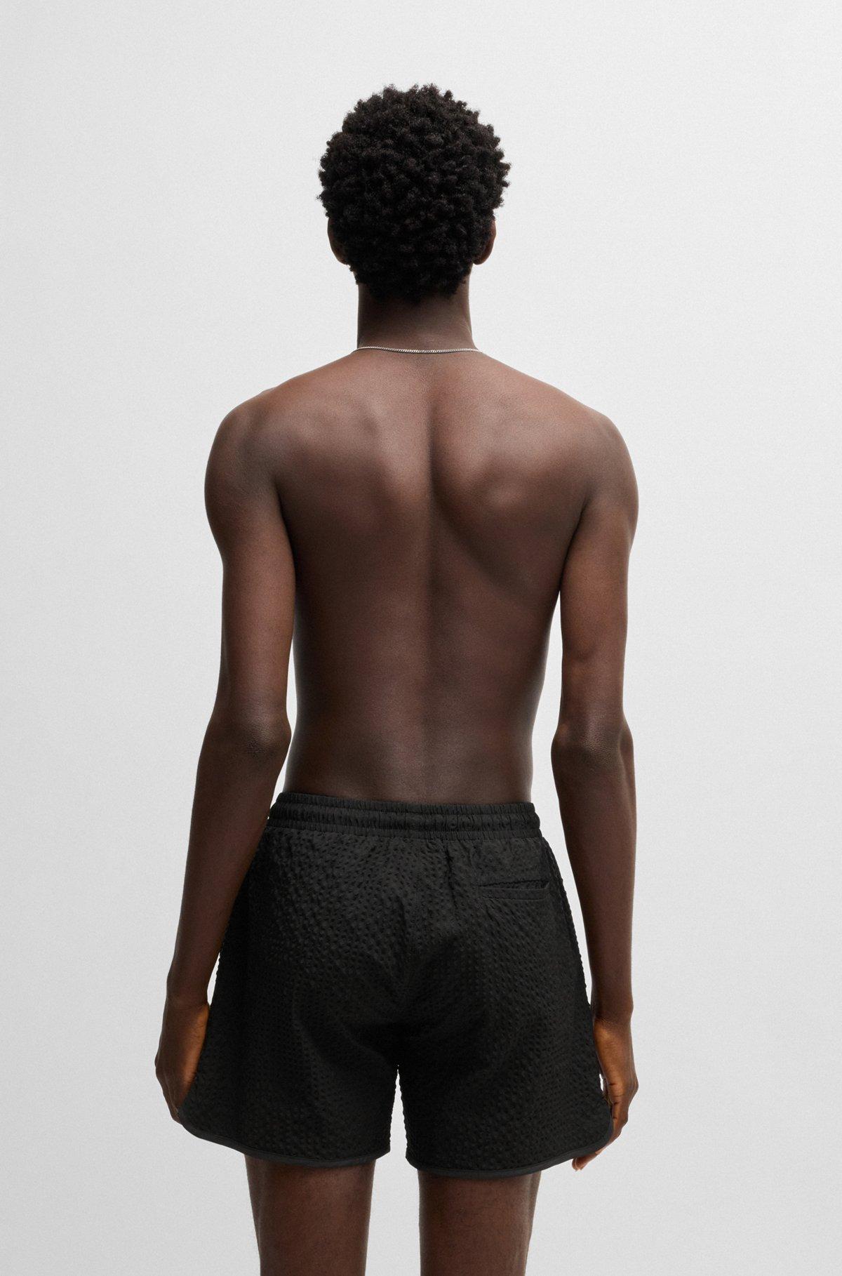 HUGO - Waffle-structured swim shorts with embroidered stacked logo - Black Product Image