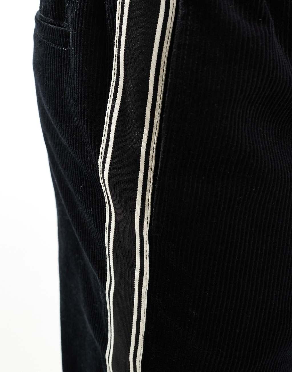 ASOS DESIGN baggy cord pants with side taping in black  Product Image