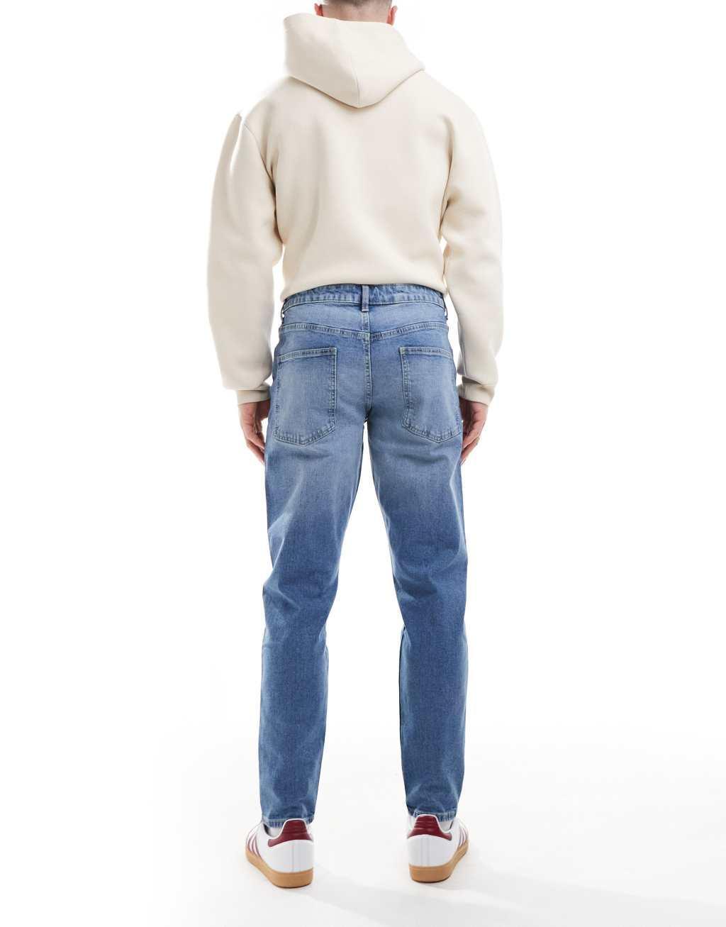 ASOS DESIGN tapered jeans in light wash blue Product Image