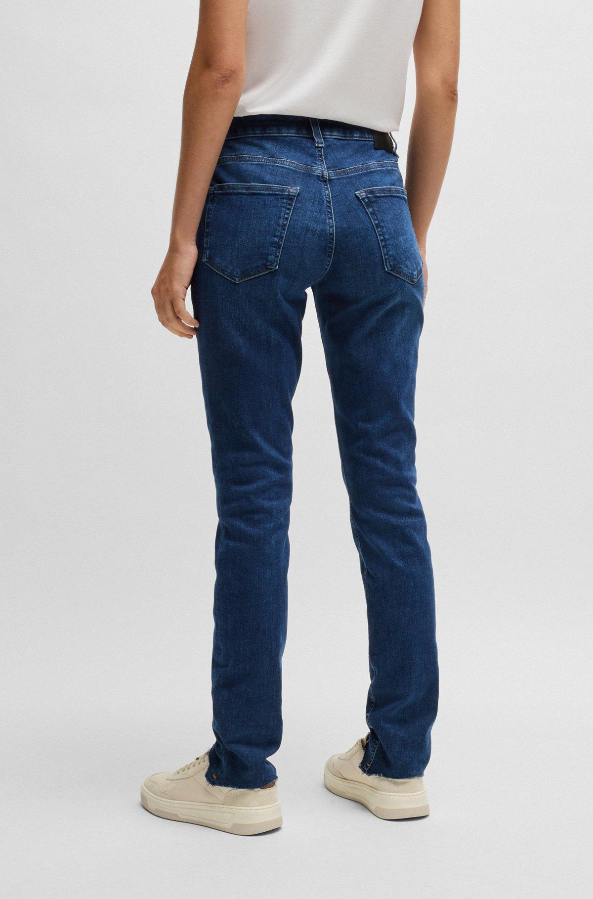 Blue jeans in distressed stretch denim with frayed hems Product Image