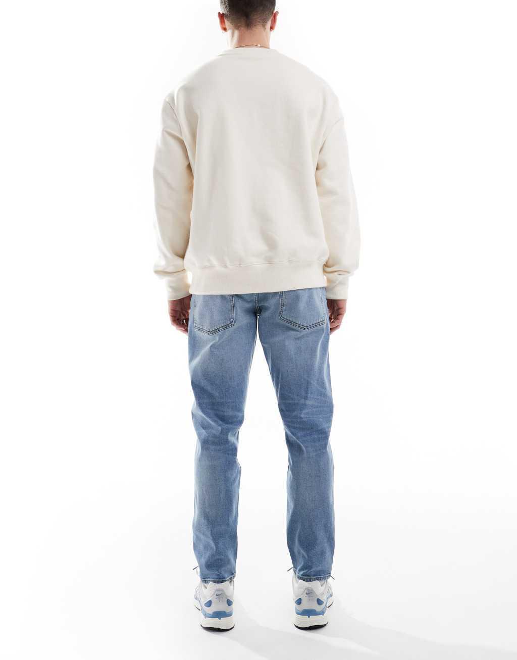 ASOS DESIGN stretch tapered jeans in light wash Product Image