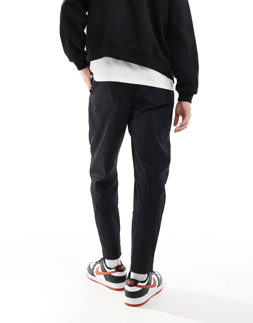 Nike Club woven tapered pants in black Product Image