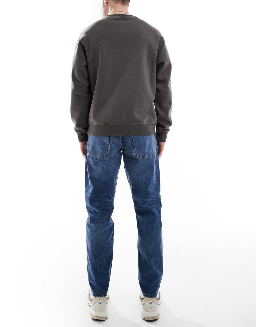 ASOS DESIGN stretch tapered jeans in mid wash Product Image