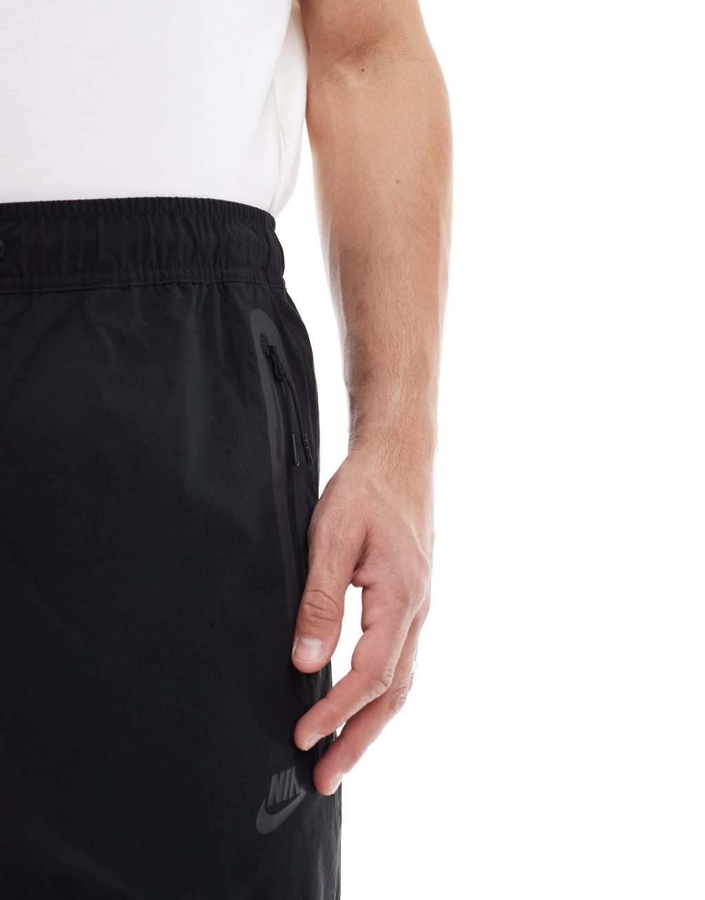 Nike Tech Woven tapered pants in black Product Image