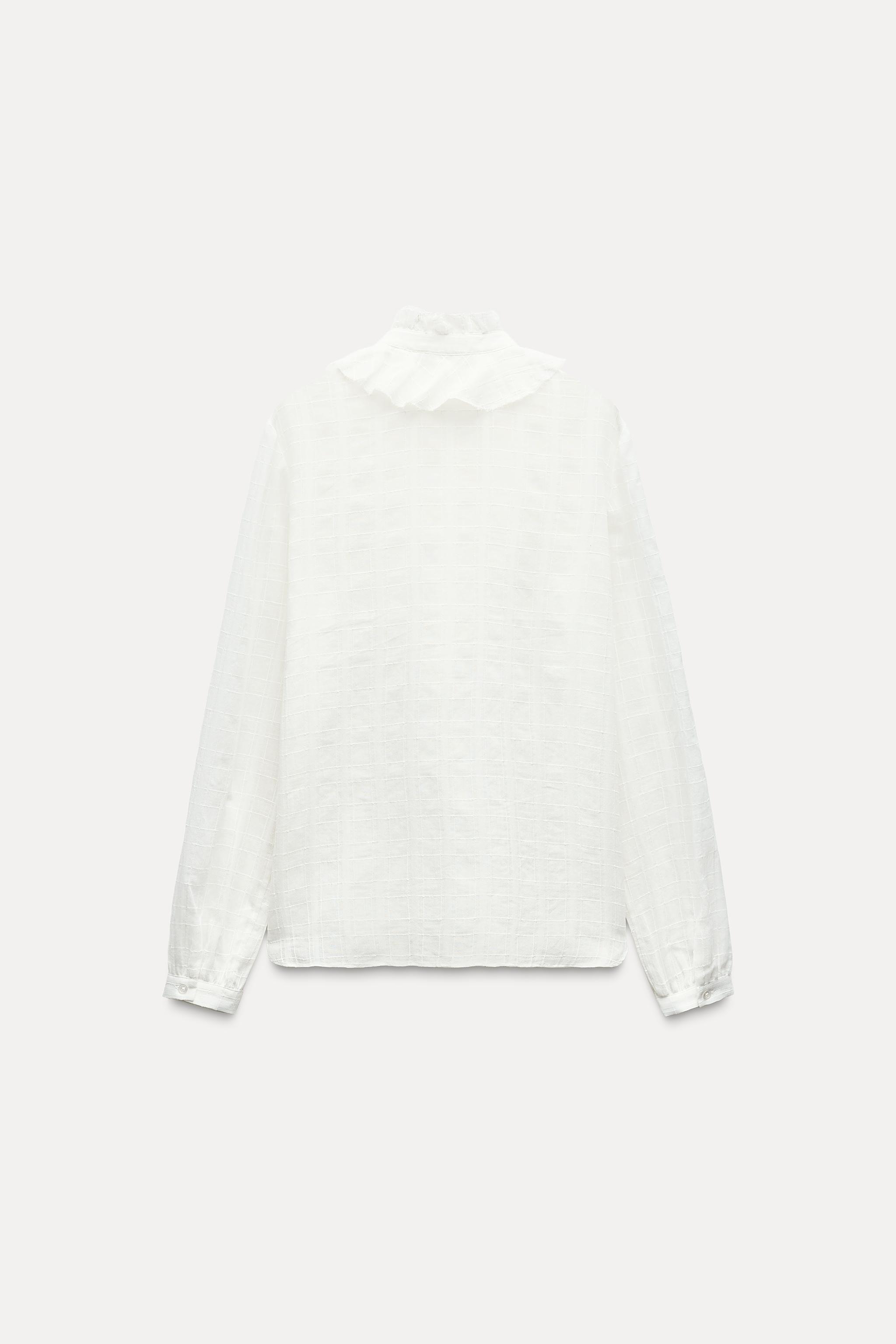 ZARA WOMAN COLLECTION<br/><br/>Blouse made with cotton. Round neck and long sleeves. Self ruffle detail. Front button closure. Product Image