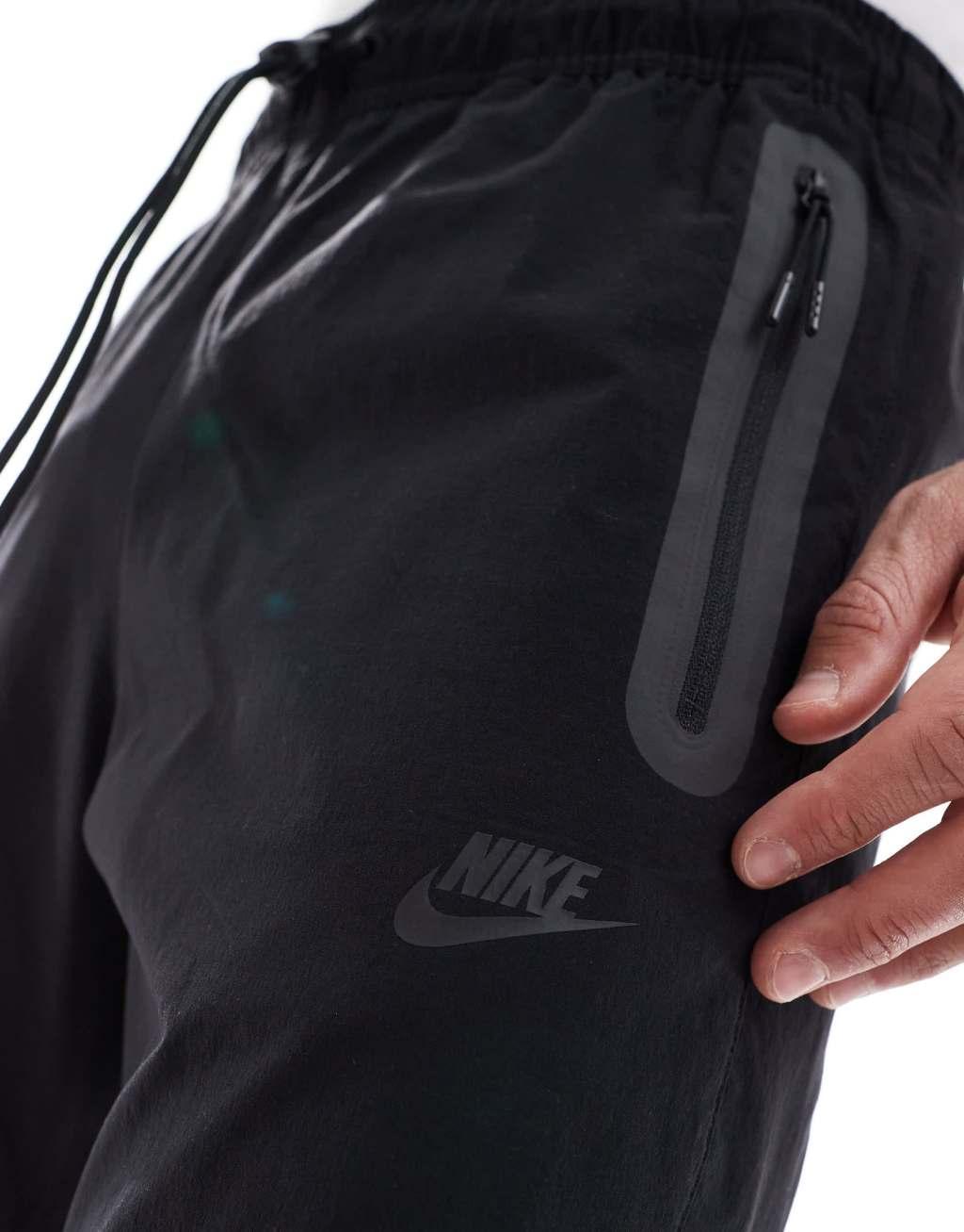 Nike Tech Woven tapered pants in black Product Image